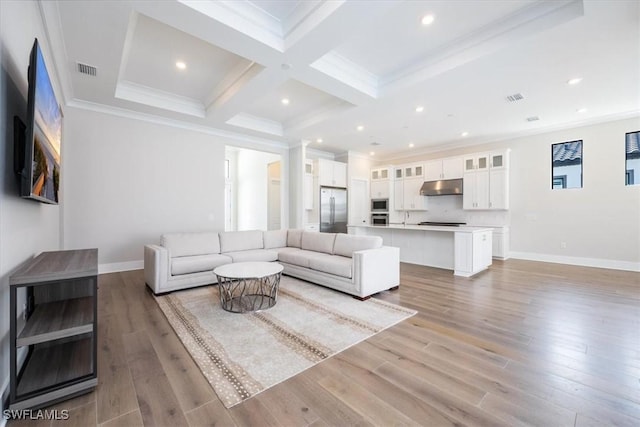 living room featuring light wood-style flooring, visible vents, coffered ceiling, and ornamental molding