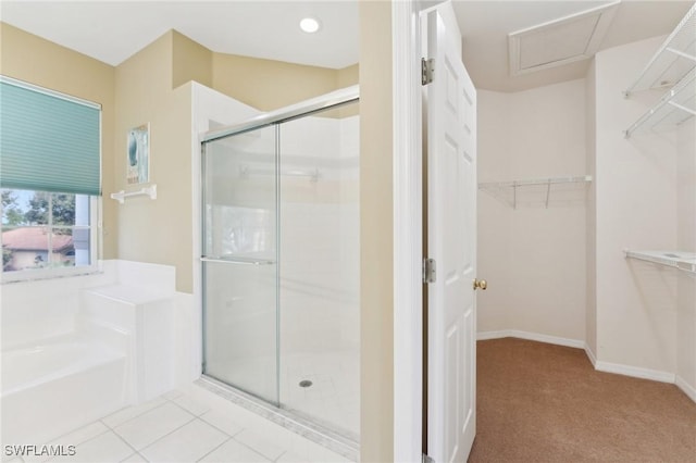 bathroom featuring baseboards, tile patterned flooring, a walk in closet, a shower stall, and a bath