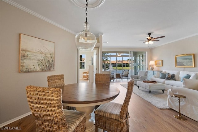 dining area with ceiling fan, ornamental molding, and wood finished floors