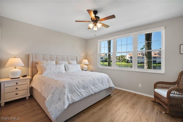 bedroom with a ceiling fan, baseboards, and wood finished floors