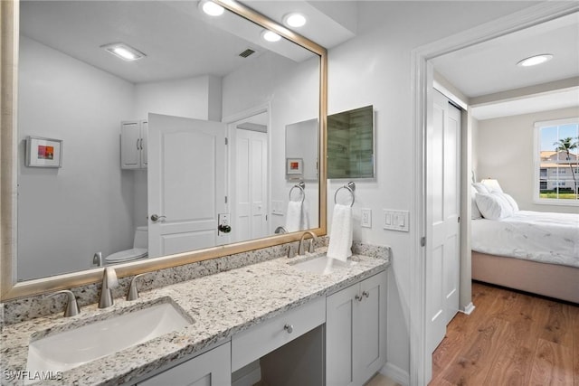 bathroom featuring visible vents, a sink, toilet, and wood finished floors