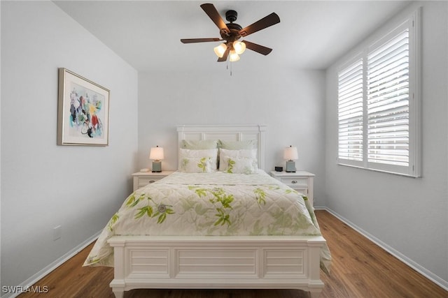 bedroom featuring a ceiling fan, baseboards, and wood finished floors