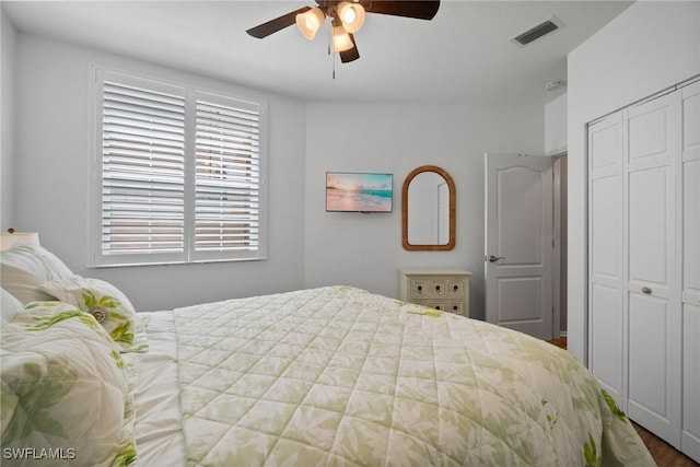 bedroom featuring ceiling fan, visible vents, and a closet