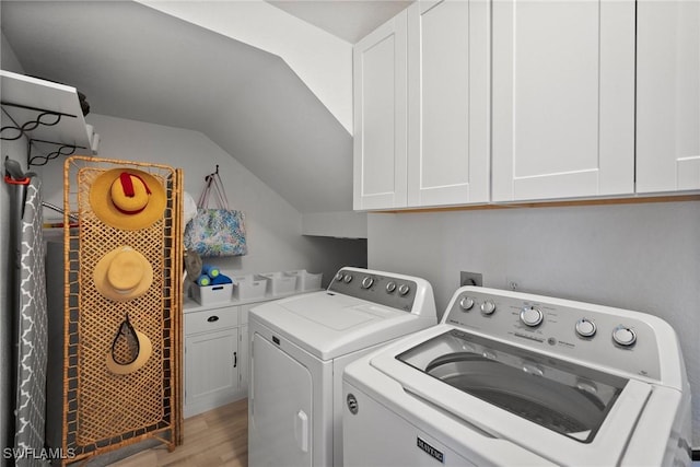 washroom featuring separate washer and dryer, light wood-type flooring, and cabinet space