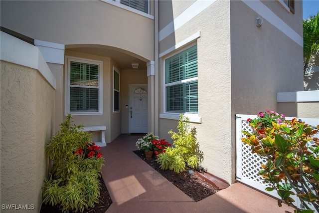 entrance to property featuring stucco siding