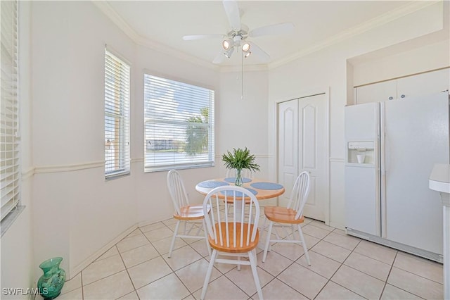 dining area featuring light tile patterned floors, a ceiling fan, and crown molding