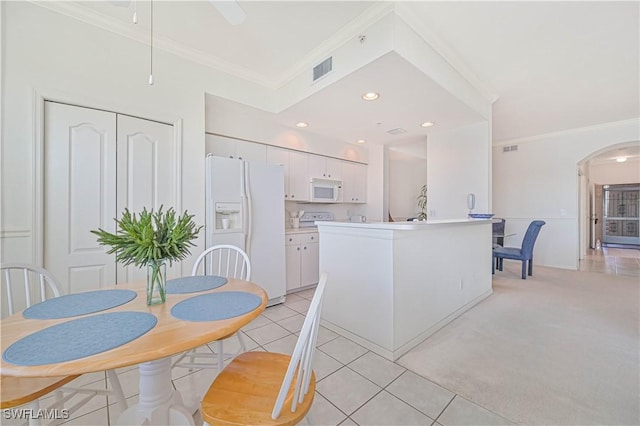 kitchen with white appliances, light tile patterned floors, visible vents, white cabinets, and ornamental molding