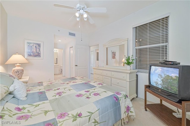 bedroom with a ceiling fan, visible vents, connected bathroom, and light colored carpet