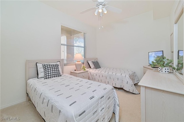 bedroom featuring light carpet, ceiling fan, and baseboards