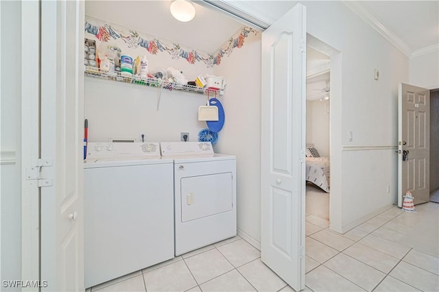 washroom featuring laundry area, light tile patterned floors, a ceiling fan, crown molding, and washing machine and dryer