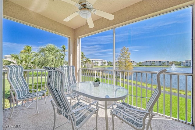 sunroom / solarium with a ceiling fan, a wealth of natural light, and a water view