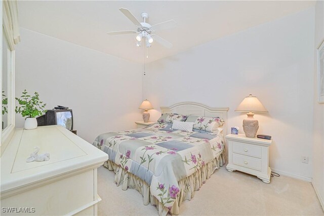 bedroom featuring a ceiling fan, light colored carpet, and baseboards