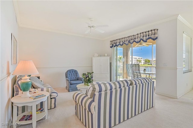 carpeted living area featuring ornamental molding and a ceiling fan