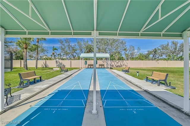 view of home's community with shuffleboard, a yard, and fence