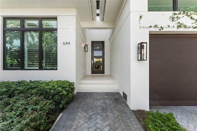 doorway to property featuring stucco siding