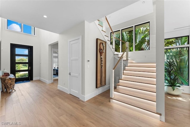 entrance foyer with stairs, recessed lighting, light wood-style flooring, and baseboards