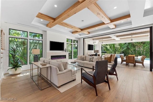 living area featuring recessed lighting, light wood-style floors, a glass covered fireplace, coffered ceiling, and beamed ceiling