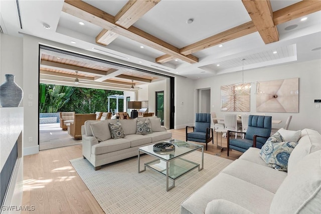 living area with light wood finished floors, baseboards, coffered ceiling, a chandelier, and beam ceiling