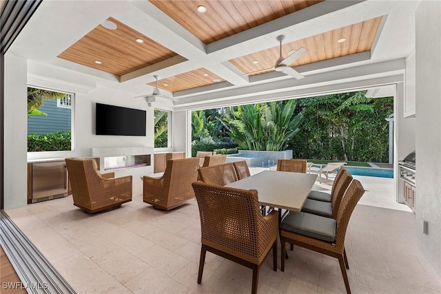 view of patio featuring a ceiling fan, an outdoor pool, exterior kitchen, and outdoor dining space