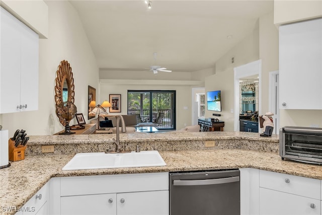 kitchen featuring a toaster, stainless steel dishwasher, open floor plan, white cabinets, and a sink