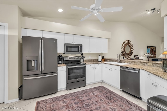 kitchen featuring white cabinets, light stone countertops, stainless steel appliances, a sink, and light tile patterned flooring