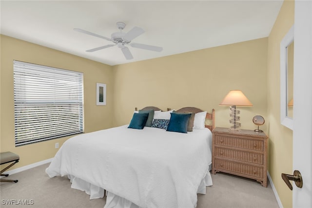 bedroom with light colored carpet, ceiling fan, and baseboards