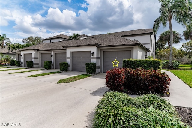 view of front of property with a garage, concrete driveway, roof with shingles, and stucco siding