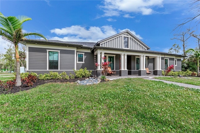 view of front of house with a porch, board and batten siding, and a front yard