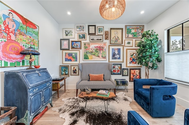 sitting room featuring baseboards, wood finished floors, and recessed lighting