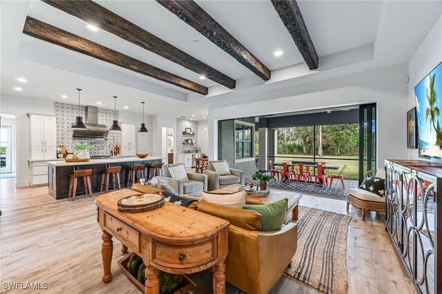 living room featuring light wood-type flooring, beamed ceiling, and recessed lighting