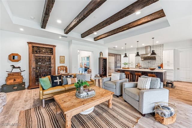 living area featuring beamed ceiling, light wood-type flooring, visible vents, and recessed lighting