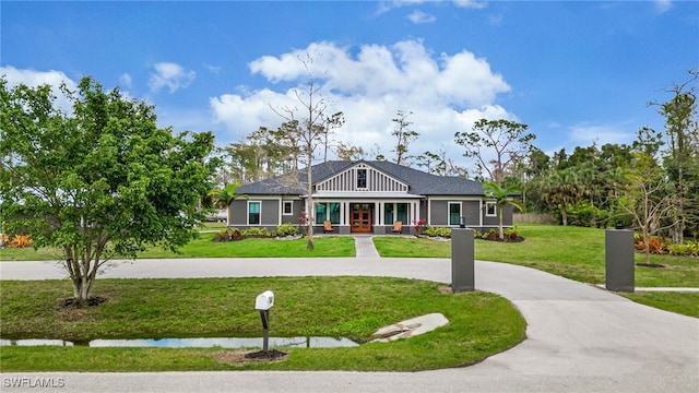 craftsman house featuring board and batten siding, a front yard, and driveway