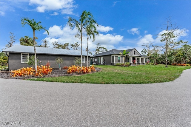 view of front of property featuring metal roof and a front yard