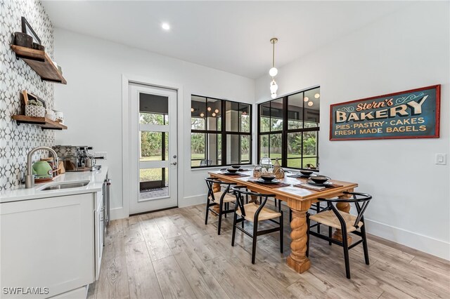 dining space featuring baseboards, plenty of natural light, and light wood finished floors