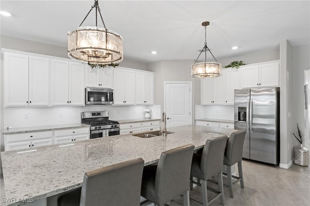 kitchen featuring white cabinets, backsplash, stainless steel appliances, and a sink