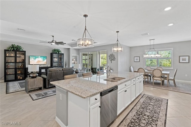 kitchen with light tile patterned floors, white cabinets, dishwasher, a kitchen island with sink, and a sink