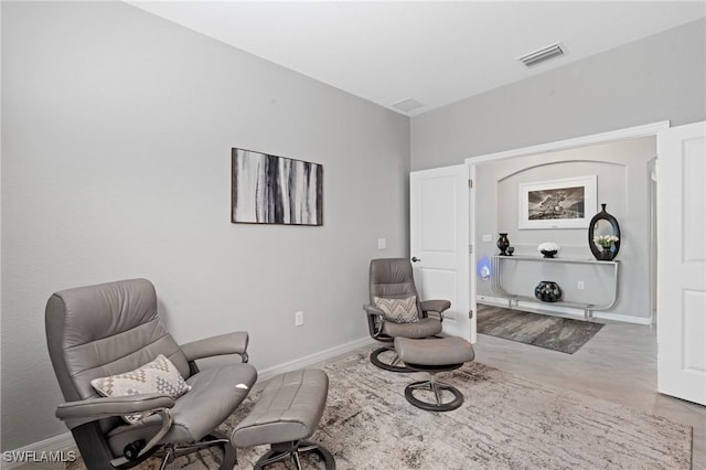 living area featuring baseboards and visible vents