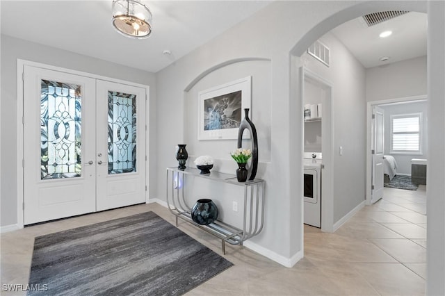 foyer featuring arched walkways, french doors, visible vents, and baseboards