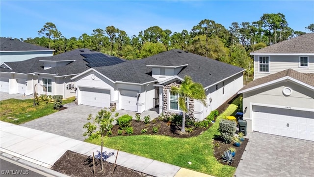 view of front of home featuring a garage, a front yard, decorative driveway, and stucco siding