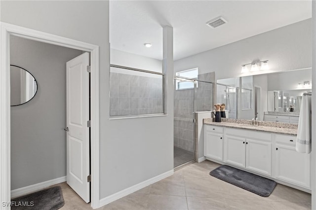 bathroom with visible vents, a shower stall, vanity, tile patterned flooring, and baseboards