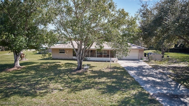 single story home featuring driveway, a sunroom, an attached garage, and a front lawn