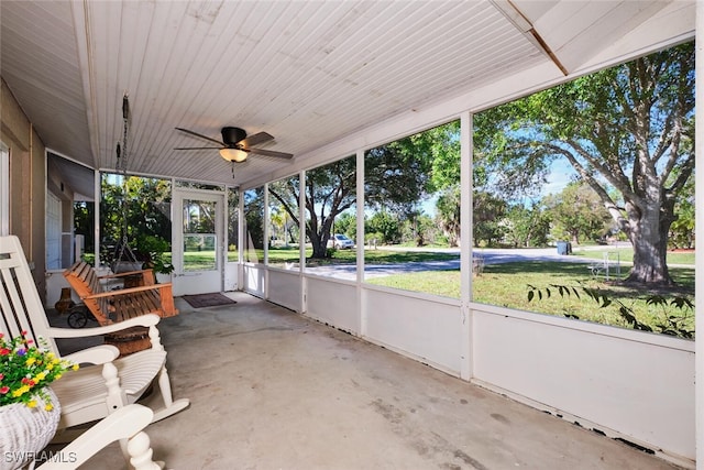 unfurnished sunroom featuring ceiling fan