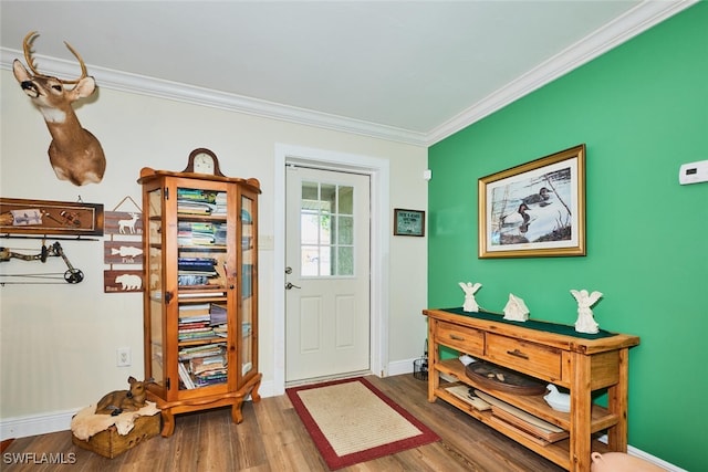 entryway featuring ornamental molding, wood finished floors, and baseboards