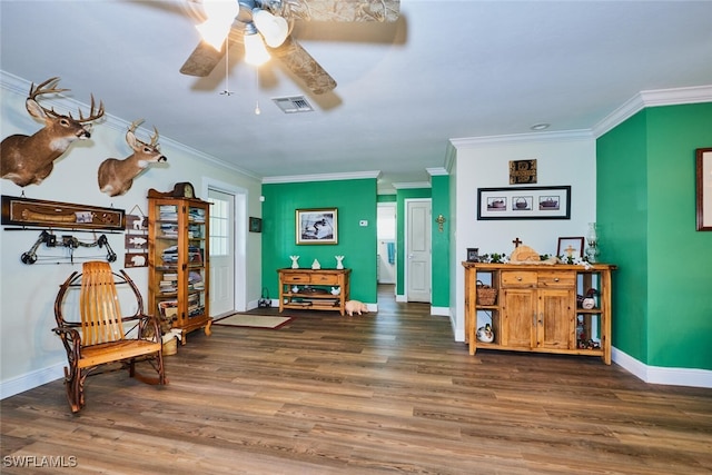 sitting room with baseboards, crown molding, visible vents, and wood finished floors