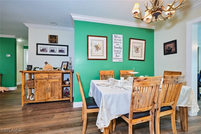 dining space featuring a chandelier, crown molding, baseboards, and wood finished floors