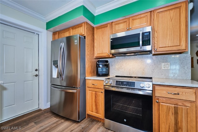 kitchen with stainless steel appliances, wood finished floors, light countertops, decorative backsplash, and crown molding