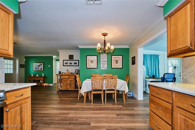 dining area featuring visible vents, a chandelier, dark wood-type flooring, and ornamental molding