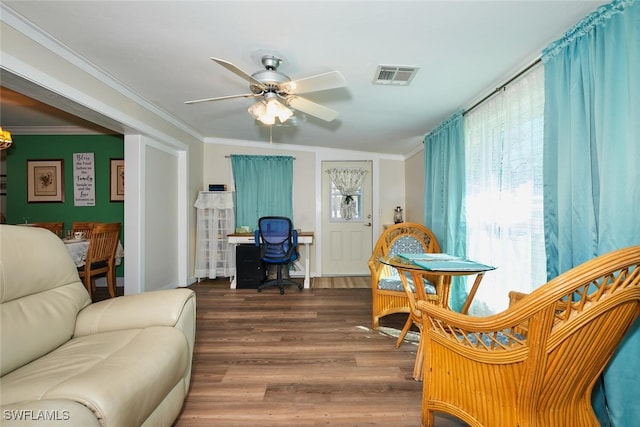 living area featuring a ceiling fan, wood finished floors, visible vents, and crown molding