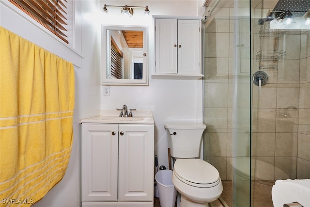 bathroom with vanity, a shower stall, and toilet