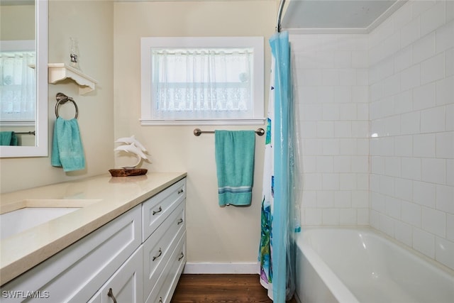 full bathroom with shower / tub combo with curtain, wood finished floors, vanity, and baseboards